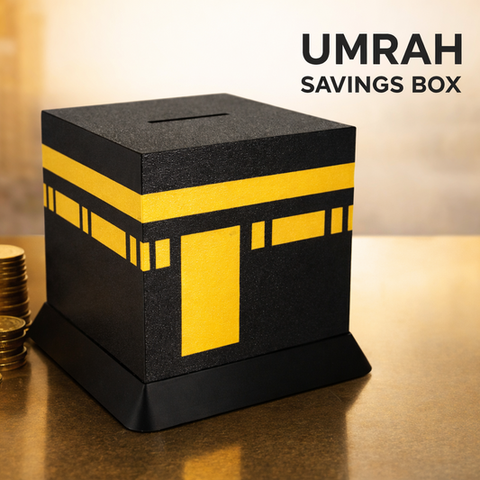 UMRAH savings box with gold coins on a reflective surface, blurred architectural background