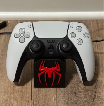 White gaming controller with a red spider logo on a wooden surface